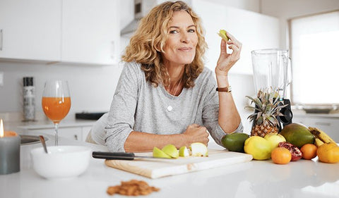 Woman eating fruits with a  knife and chopping board