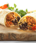 A delicious burrito with a filling of meat, beans, cheese, and vegetables, wrapped in a soft tortilla.